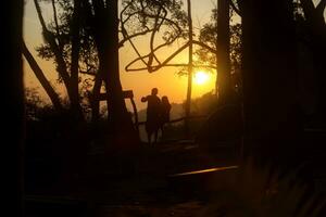 silhuetas do amada dentro amor às nascer do sol. foto