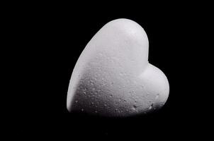 uma branco coração em forma objeto em uma Preto fundo foto