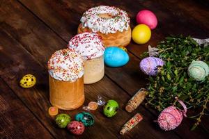 bolo de páscoa e ovos coloridos em um fundo escuro foto