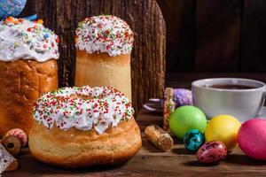 bolo de páscoa e ovos coloridos em um fundo escuro foto