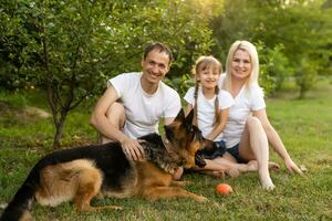 retrato do alegre estendido família sentado dentro a parque foto