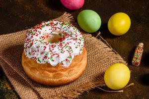 bolo de páscoa e ovos coloridos em um fundo escuro foto