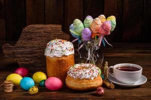 bolo de páscoa e ovos coloridos em um fundo escuro foto