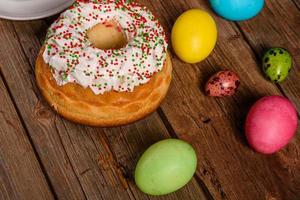 bolo de páscoa e ovos coloridos em um fundo escuro foto