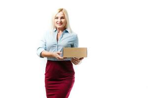 uma jovem lindo caucasiano mulher segurando uma caixa dentro dela mãos. foto
