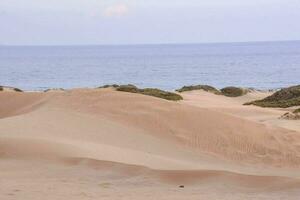 uma pessoa caminhando em a areia dunas foto