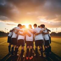 ai gerado uma grupo do jovem futebol jogadoras amontoado juntos dentro uma equipe falar, com a Sol configuração atrás eles foto