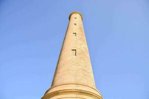 a alta pedra torre é contra uma azul céu foto