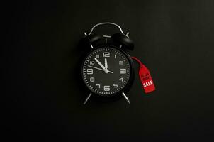alarme relógio com palavra às vermelho preço tag em Sombrio fundo para Preto Sexta-feira compras venda lembrete conceito. foto