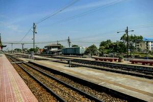 uma trem estação com uma plataforma e faixas foto