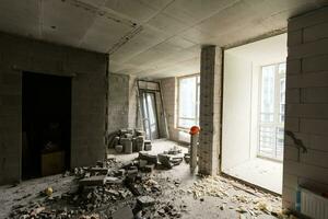 abandonado casa interior, sujo sala, podre descascado paredes. foto