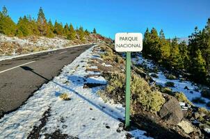 uma placa este diz parque nacional em uma Nevado estrada foto