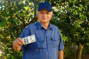 alegre Senior segurando dinheiro Pacotes dentro a jardim fundo foto