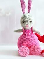 ai gerado tricotado Coelho dentro Rosa vestir. st. dia dos namorados dia decoração. tricotado brinquedo, amigurumi. dia dos namorados dia cumprimento cartão ai gerado foto