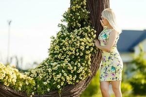 lindo jovem mulher dentro agradável vestir posando em colorida parede do flores moda foto, agradável cabelo, grande sorrir foto