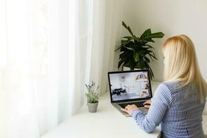 uma mulher é trabalhando remotamente usando vídeo conferência e Encontros e trabalhos remotamente a partir de lar, bem sucedido trabalhos foto