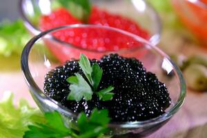 particionado prato com Preto e vermelho caviar em de madeira fundo foto