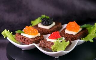 Preto vermelho caviar em sanduíches, decorado com vegetação. restaurante Comida café da manhã jantar almoço foto