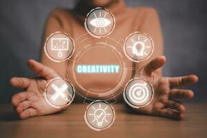 criatividade conceito, o negócio pessoa mão segurando criatividade ícone em virtual tela. foto