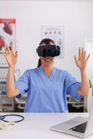 médico enfermeira experimentando virtual realidade usando vr óculos dentro hospital escritório. terapeuta usando médico inovação equipamento dispositivo copos, futuro, medicamento, médico, assistência médica, profissional, visão, simulador. foto