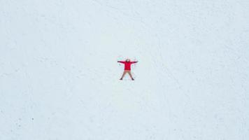 vista superior aérea do homem fazendo anjo da neve foto