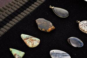 uma variedade do pedras e pingentes em uma Preto pano foto