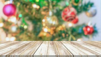 tampo de mesa de madeira vazio com árvore de natal desfocada com fundo claro bokeh foto