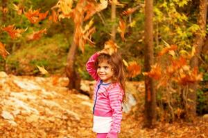 doce pequeno menina dentro outono floresta foto