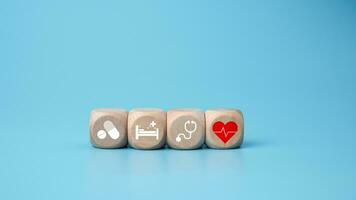 de madeira blocos com médico símbolo ícones em azul fundo representando saúde conceito com tratamento e remédio. foto