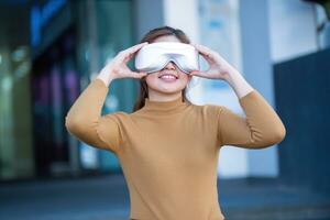 lindo ásia mulher com virtual realidade ao ar livre vr óculos equipamento às a departamento loja foto