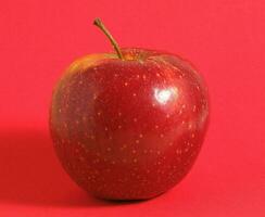 a maçã é mostrando em uma vermelho fundo foto