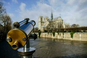 uma telescópio é olhando às a catedral dentro Paris foto