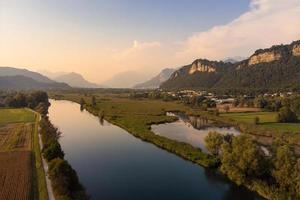 vista aérea de um rio e campo ao pôr do sol foto