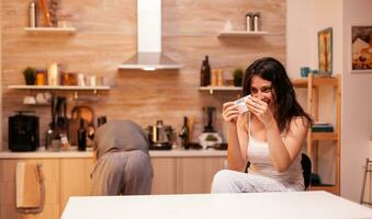 mulher usando ilegal narcóticos dentro casa cozinha.. anfetamina Abuso com lado efeitos sofre a partir de dor fazer convulsões, social desastre e narcóticos vício epidemia. foto