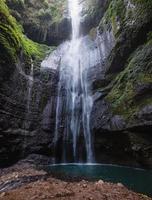 Cachoeira majestosa fluindo em penhasco rochoso na floresta tropical
