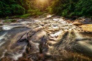 pequeno cascata e pedra com água movimento. foto