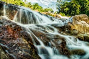 pequeno cascata e pedra com água movimento. foto