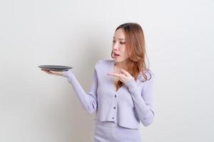 retrato linda mulher asiática segurando um prato vazio foto