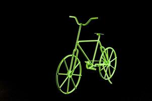 uma néon verde bicicleta é mostrando contra uma Preto fundo foto