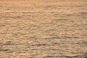 pequeno ondas dentro a oceano às pôr do sol foto