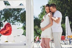 casal jovem e feliz grávida, abraçando-se na natureza. momentos românticos foto