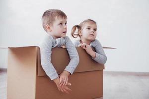 dois filhos, menino e menina, acabaram de se mudar para uma nova casa. foto do conceito ... as crianças se divertem.