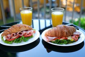 seis peças do bacon enrolado para dentro uma sanduíche croissant alface folhas brie queijo café da manhã chique Comida em uma Preto prato restaurante servindo servindo tomate ao ar livre verão foto