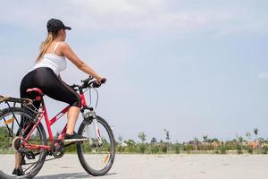 vista traseira de mulher andando de bicicleta em um parque