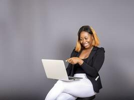 lindo africano senhora usando dela computador portátil foto