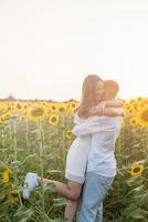 lindo casal se divertindo em campos de girassóis foto