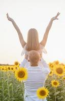 lindo casal se divertindo em campos de girassóis foto