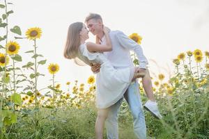 lindo casal se divertindo em campos de girassóis foto