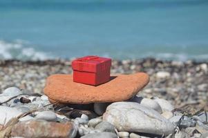 caixa de presente vermelha no fundo da costa do mar foto
