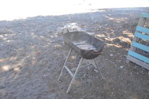 braseiro de metal para cozinhar carne fica na areia foto